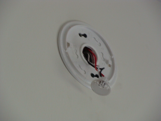 Smoke detector has been removed from bedroom wall. It is important to remember that when replacing detectors that are hard-wired together, that all must be compatible for the system to operate properly and offer the intended safety feature.